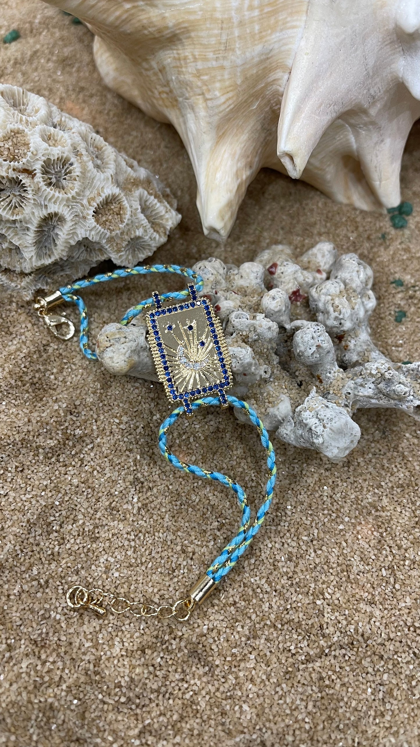 bracciale cordoncino con amuleto portafortuna in metallo placcato oro e zirconi bianchi e azzurri