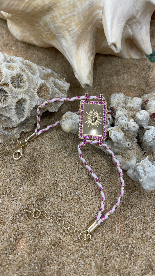 bracciale in cordoncino con amuleto portafortuna in metallo placcato oro e zirconi fuxia