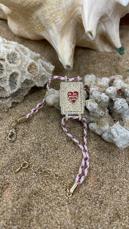 bracciale cordoncino con amuleto portafortuna in metallo placcato oro e zirconi bianchi