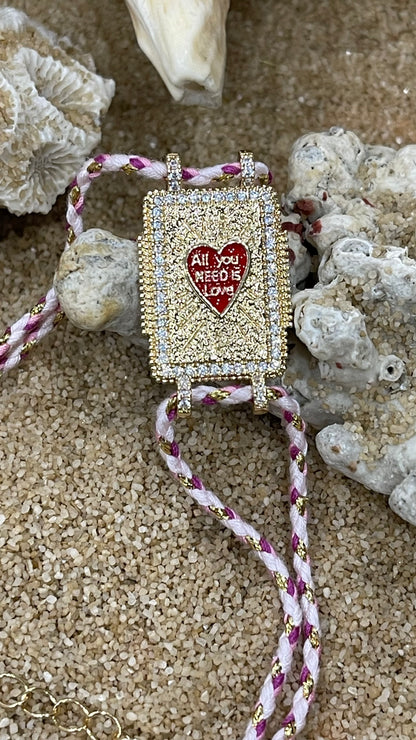 bracciale cordoncino con amuleto portafortuna in metallo placcato oro e zirconi bianchi